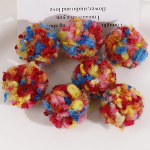 Close-up of 30mm colorful fluffy pom-poms made of soft mixed yarn for DIY jewelry