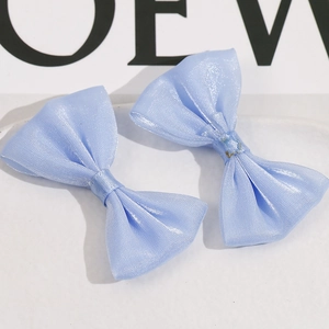 Vista de detalle de dos lazos de malla azul claro de doble capa para el cabello en blanco