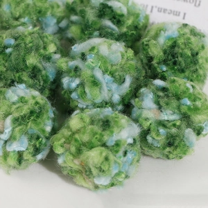 Macro detail of 30mm fluffy mixed green and blue plush pom-poms for DIY jewelry