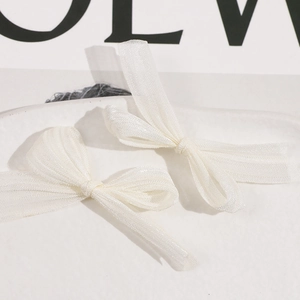 Detail of white handmade mesh bow hair clips with elegant translucent layered fabric