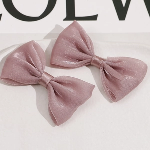 Detalle de lazos para el pelo en malla suave rosa con sutil textura brillante