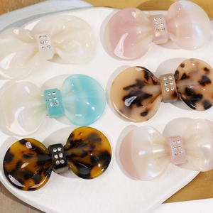 Bow hair clips in pearl white, pink, blue, and tortoiseshell acetate with crystal accents