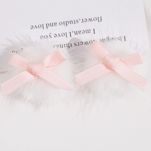 Détail de barrettes à pompon blanc avec nœuds en ruban rose pour décoration de cheveux DIY