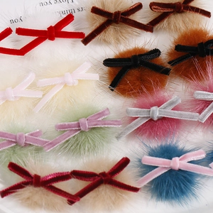 Detailed macro view of assorted colorful velvet ribbon bows with soft plush pom poms