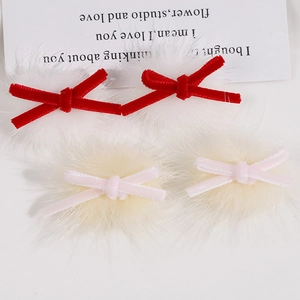 Detail of plush velvet ribbon bows in red and pink with soft faux fur pompom accents