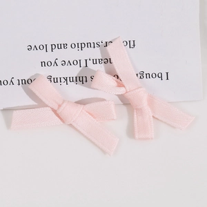 Détail macro de deux nœuds en ruban rose clair faits main pour accessoires cheveux DIY
