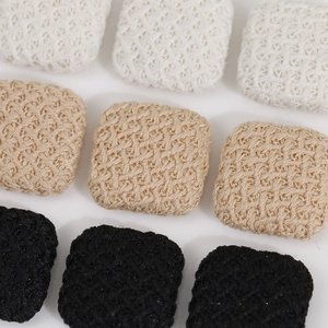Macro detail of square knitted decorative buttons in black, beige and white textured fabric