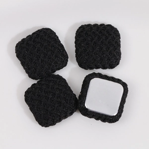 Detailed view of four black square woven texture DIY charms with smooth metal backings