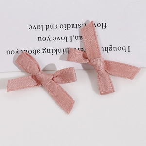 Vue détaillée de deux pinces à cheveux avec nœuds en tissu rose faits à la main sur carte