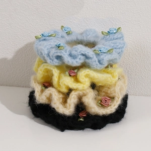 Detail of plush knitted hair scrunchies with handmade ribbon rose flowers and leaves