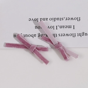 Detail of pink velvet ribbon bow hair clips with soft textured flocking on white background