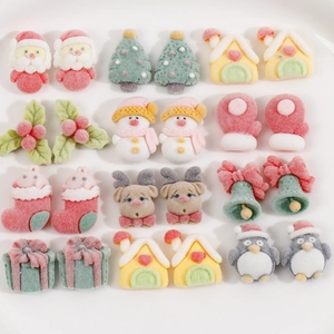 Macro detail of flocked resin Christmas DIY charms including snowman and reindeer shapes