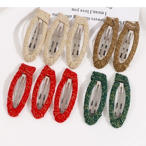 Close-up of woven fabric BB hair clips with gold thread detail in four assorted colors