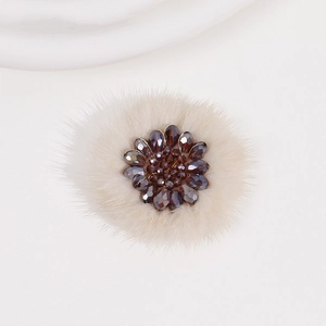 Detailed close-up of handmade plush winter flower with crystal beads and soft white faux fur