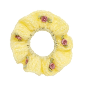 Handmade crochet hair scrunchie in yellow yarn with five small pink ribbon roses