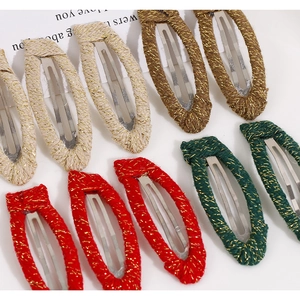 Detailed view of woven fabric hair clips with gold thread texture and metallic BB clip base