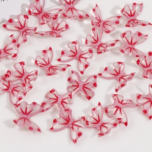 Macro detail of translucent pink butterfly resin beads for DIY jewelry with pre-drilled holes