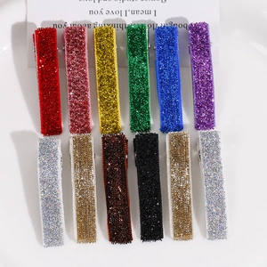 Gros plan de 12 barrettes à cheveux colorées à paillettes dans un bol blanc minimaliste