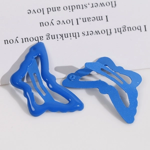 Dettaglio di fermagli a farfalla blu con finiture lucide e opache su sfondo bianco pulito
