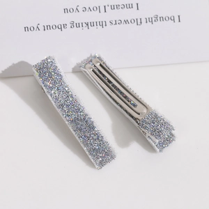 Détail de barrettes à cheveux argentées pailletées avec finition en sequins tissés