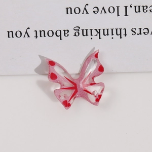 Macro detail of translucent pink butterfly pendant with glitter finish and pre-drilled hole