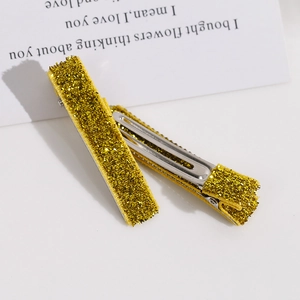 Gros plan de pinces à cheveux à paillettes dorées avec base en métal argenté et sequins