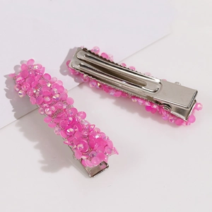 Dettaglio delle paillettes rosa lucide e della clip in metallo dei fermagli per capelli