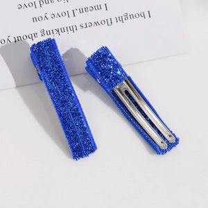 Gros plan de pinces à cheveux en métal argenté avec tissu à paillettes bleu royal