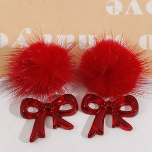 Detail of plush red pompom with translucent resin bowknot DIY jewelry accessory