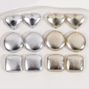 Macro view of geometric metallic fabric buttons in gold and silver for DIY jewelry