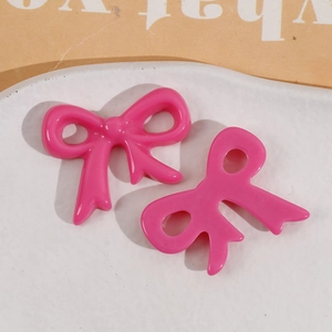 Close-up of pink glossy resin bow charms for DIY jewelry and hair accessory making