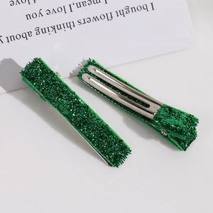 Détail de pinces à cheveux à paillettes vertes avec support métallique brillant en paire