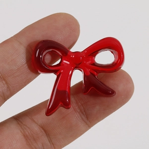 Macro shot of a red transparent resin bow-knot accessory with a glossy finish for DIY crafts