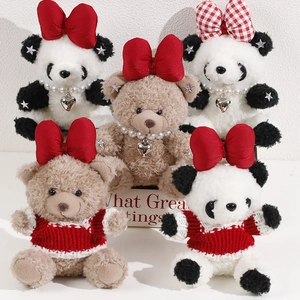 Detail of plush bear charms with bows, pearl necklaces, and red knit sweaters