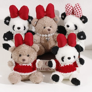 Detail of plush teddy bears and pandas featuring red bows, pearls, and knit sweaters
