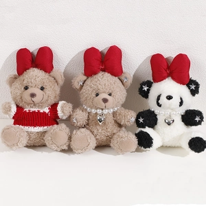 Detail view of plush bear pendants with red bows, striped sweaters and pearl heart charms