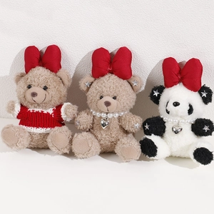 Plush teddy bear and panda dolls with large red bows and pearl heart necklaces