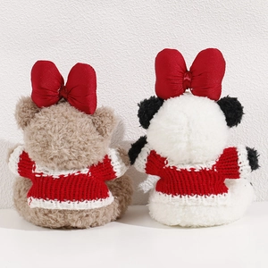 Detail of plush bear and panda toys wearing red bows and knit sweaters from back view