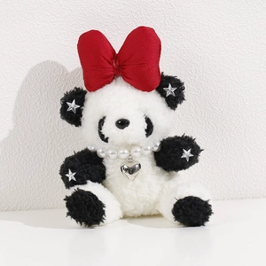 Detail view of plush panda toy with a large red bow, pearl necklace, and silver heart charm