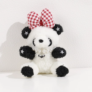 Close-up of plush panda doll with red bow, pearl necklace and silver heart pendant