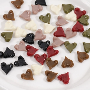 Close-up of heart-shaped resin charms in various colors for DIY jewelry making accessories