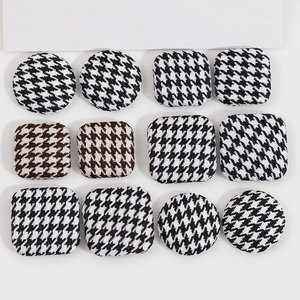 Macro detail of houndstooth fabric covered decorative buttons in round and square shapes