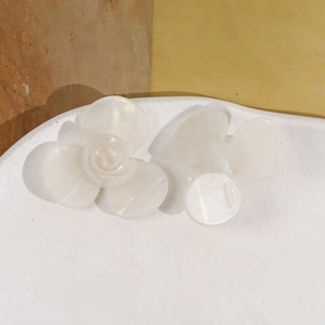 Vue détaillée de mini pinces à fleurs en acétate nacré sur une assiette en céramique