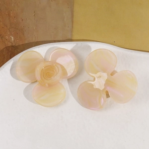 Lot de barrettes fleurs en acétate jaune dégradé posé sur un plateau en céramique