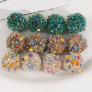 Vue macro de pompons en peluche de 2cm en vert, marron et beige pour accessoires DIY