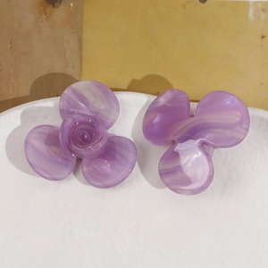 Détails de la texture marbrée violette sur les pinces à cheveux fleur en acétate
