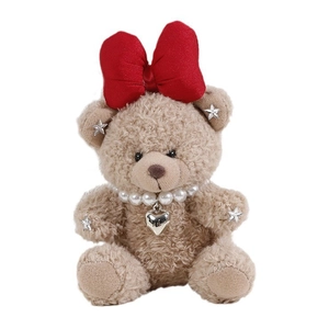 Cute brown plush teddy bear with a large red bow and pearl necklace on white background