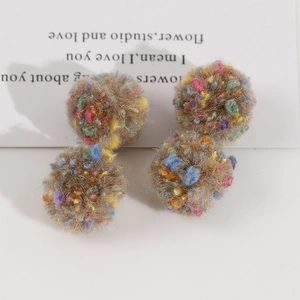 Gros plan de quatre pompons en peluche multicolores de 2cm pour bijoux et accessoires DIY