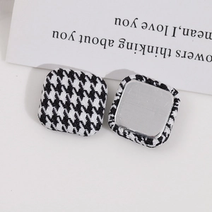 Close-up of square houndstooth fabric buttons with silver metal back for DIY jewelry