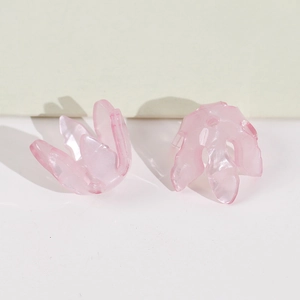 Gros plan de perles fleurs roses translucides avec trous pour création de bijoux DIY